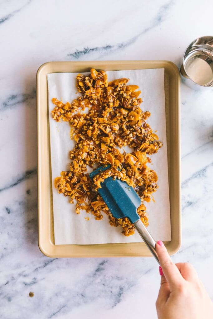 spreading cereal brittle on baking sheet with a silicone spatula.
