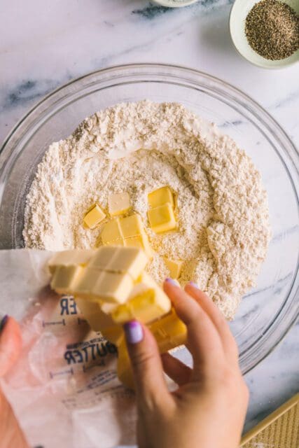 adding butter into flour for buttermilk biscuits