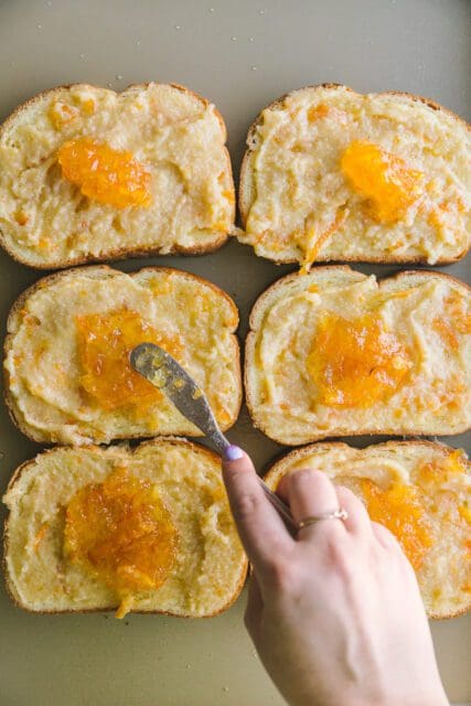 spreading orange frangipane on bread for a Mardi Gras dessert