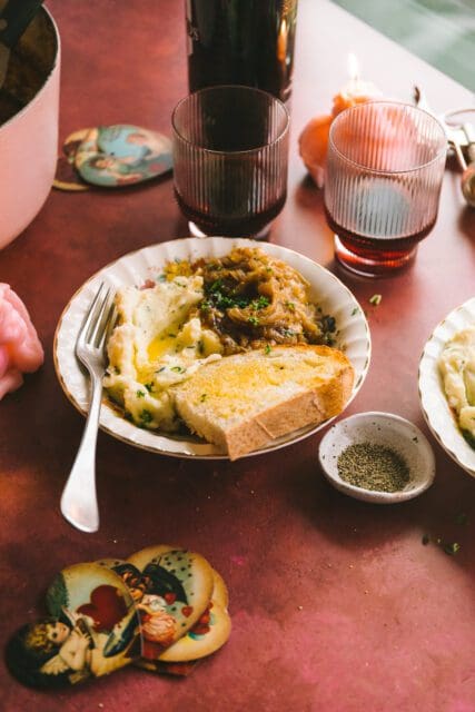 French onion chicken in a bowl surrounded by glasses on a table