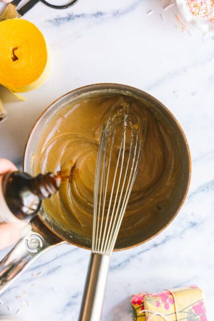 whisking ingredients together, adding vanilla for a birthday cake frosting