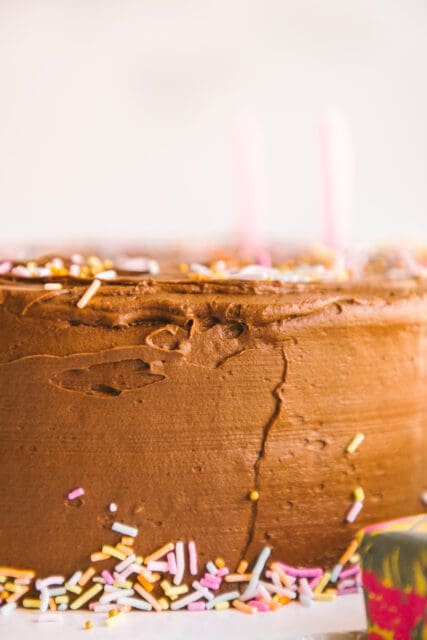 close shot of birthday cake frosting, candles blurred