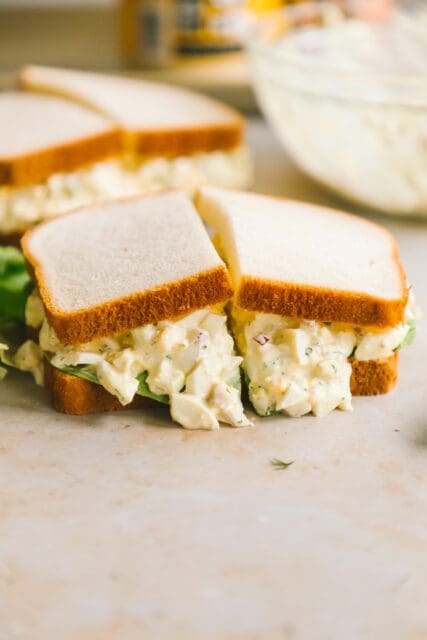 egg salad spilling over and cut in half