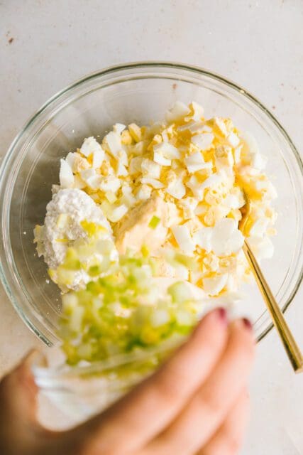 adding chopped celery to the egg salad recipe