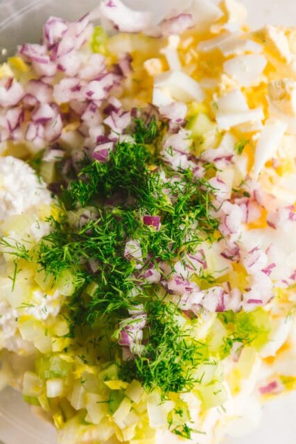 adding chopped fine herbs to the egg salad recipe