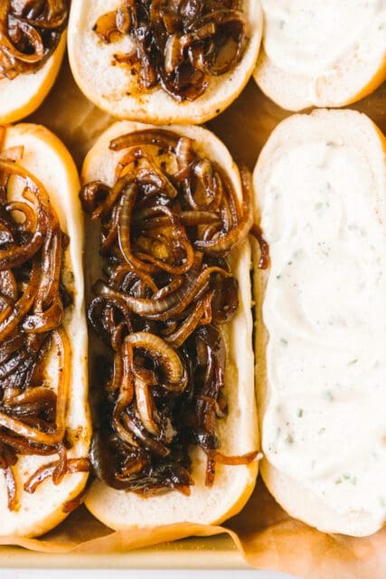 caramelized onions on one side of a hoagie roll, horseradish mayo on the other side