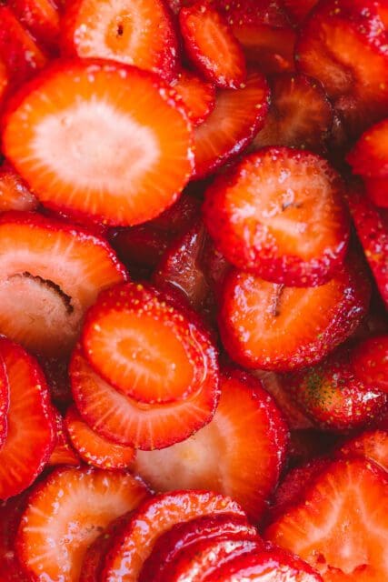 close up of sliced strawberries in sugar for strawberry shortcake recipe