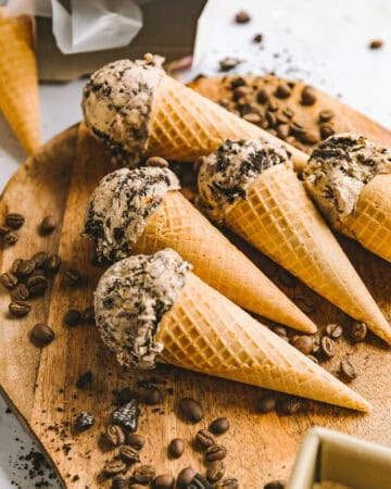 ice cream cones on a wooden board surrounded by coffee beans