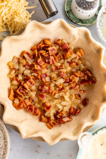 cooked, crispy bacon and onions in a prepped pie crust