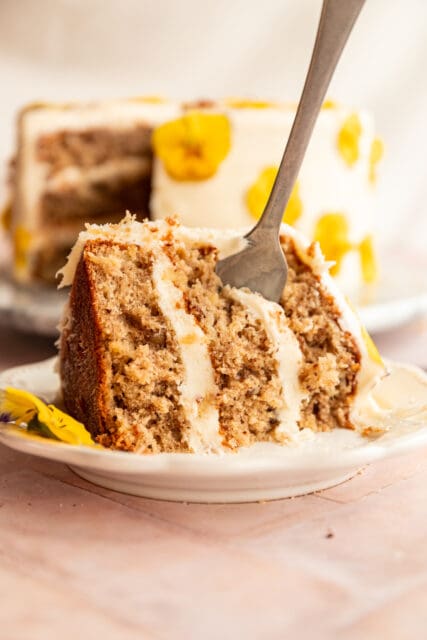 stick a fork in me, it's done! hummingbird cake, layers of cake and cream cheese frosting, on a plate