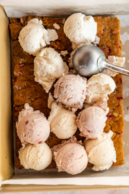 scooping strawberry and vanilla ice cream onto freshly baked and cooled blondies